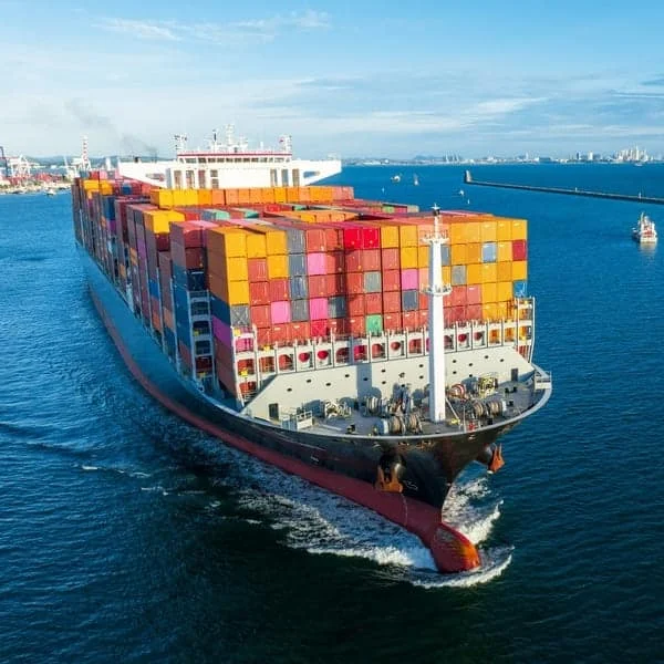 Barco contenedor navegando en alta mar, transportando maquinaria agrícola en ruta internacional