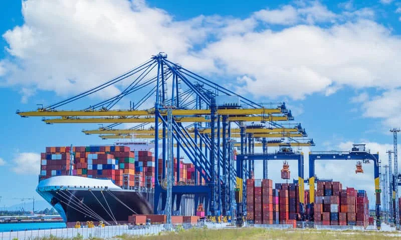 Barco de carga atracado en puerto internacional listo para operaciones logísticas de exportación