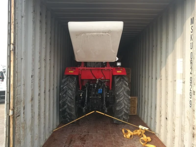 Tractor rojo Cropilots de 70 caballos de fuerza siendo cargado para envío