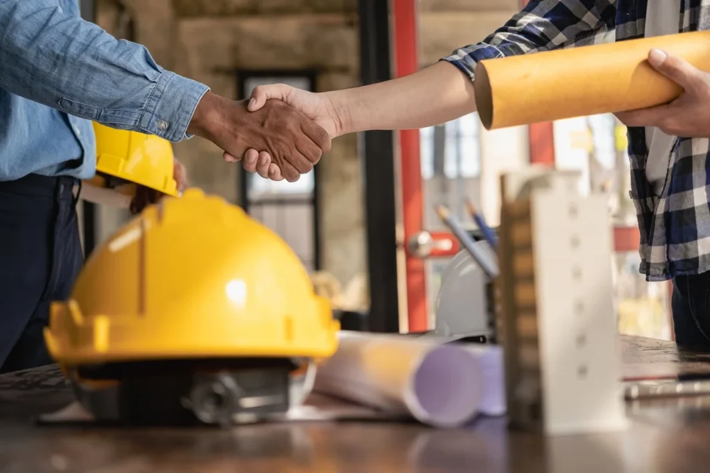 Dos personas estrechando manos en señal de acuerdo, colaboración o cierre de trato comercial