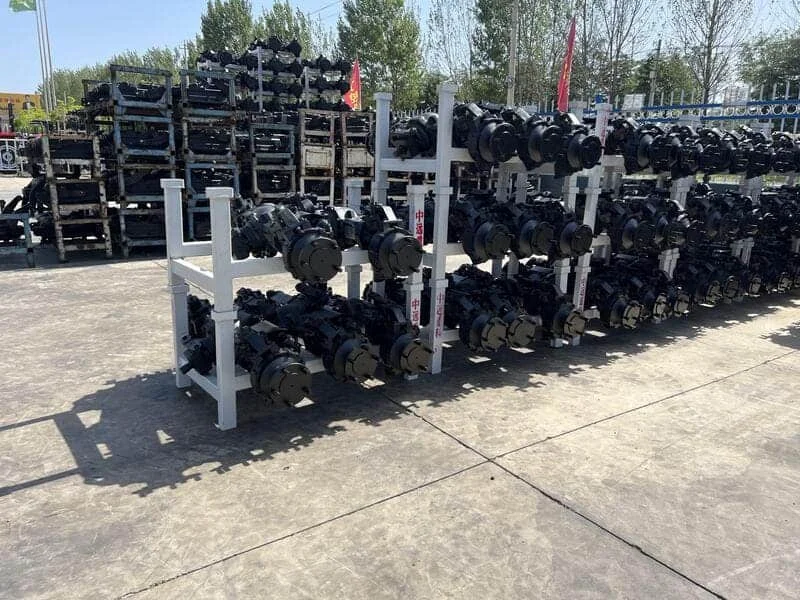 Ejes delanteros de tractores Cropilots almacenados en patio exterior organizados por modelo y tamaño