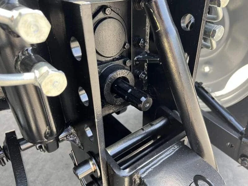 Primer plano de la toma de fuerza (PTO) trasera de un tractor agrícola con eje visible