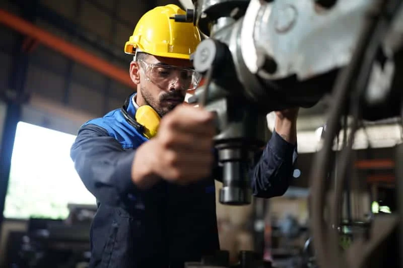Trabajadores locales realizando ajustes técnicos y pruebas de funcionamiento en equipo agrícola