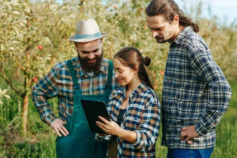 Tres personas comunicándose con soporte técnico para resolver dudas o problemas relacionados con maquinaria agrícola