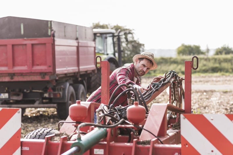 Agricultor aprendiendo los conceptos básicos de operación de un tractor agrícola en campo abierto