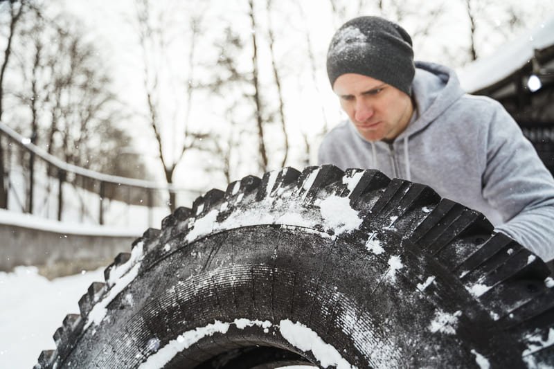 Agricultor evaluando tipos de neumáticos para tractor diseñados para uso en nieve y hielo
