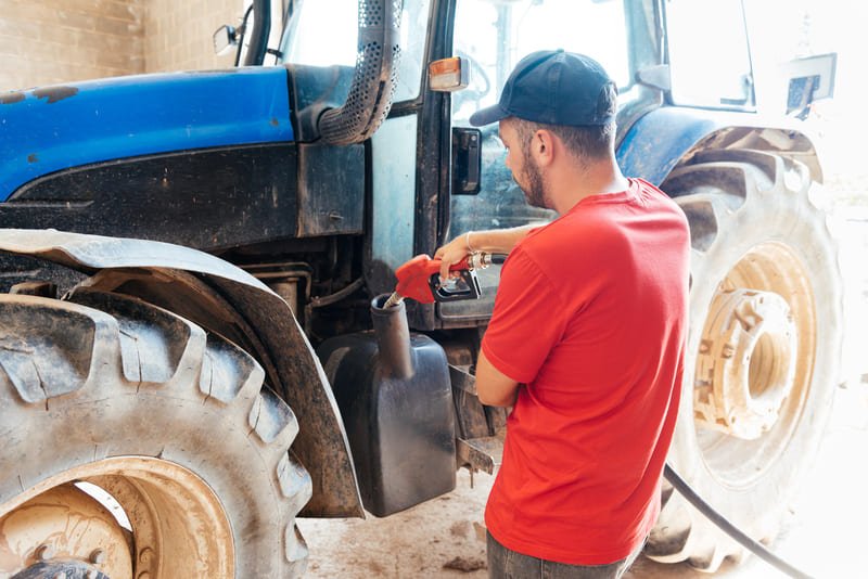 Técnico reparando tractor agrícola a tiempo para evitar retrasos y daños en los cultivos