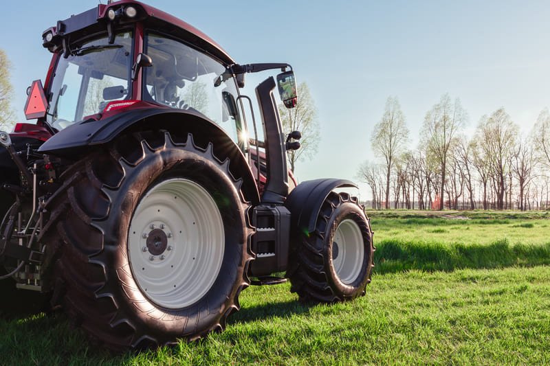 Llantas de tractor agrícola alineadas esperando inspección en taller de maquinaria pesada.