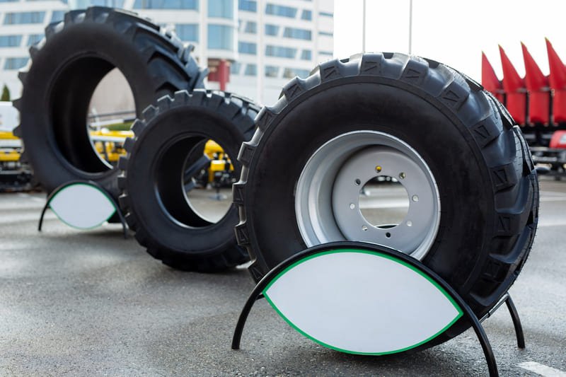 Primer plano de neumáticos de tractor agrícola mostrando el diseño de la banda de rodadura resistente.