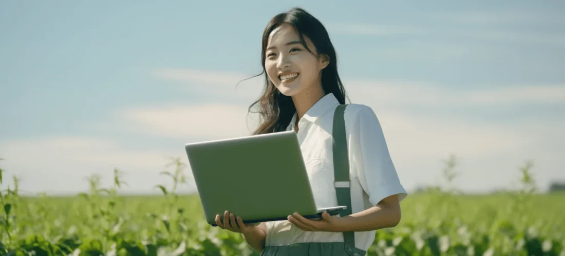 Mujer sosteniendo una laptop en un campo agrícola, analizando datos o gestionando información de cultivo